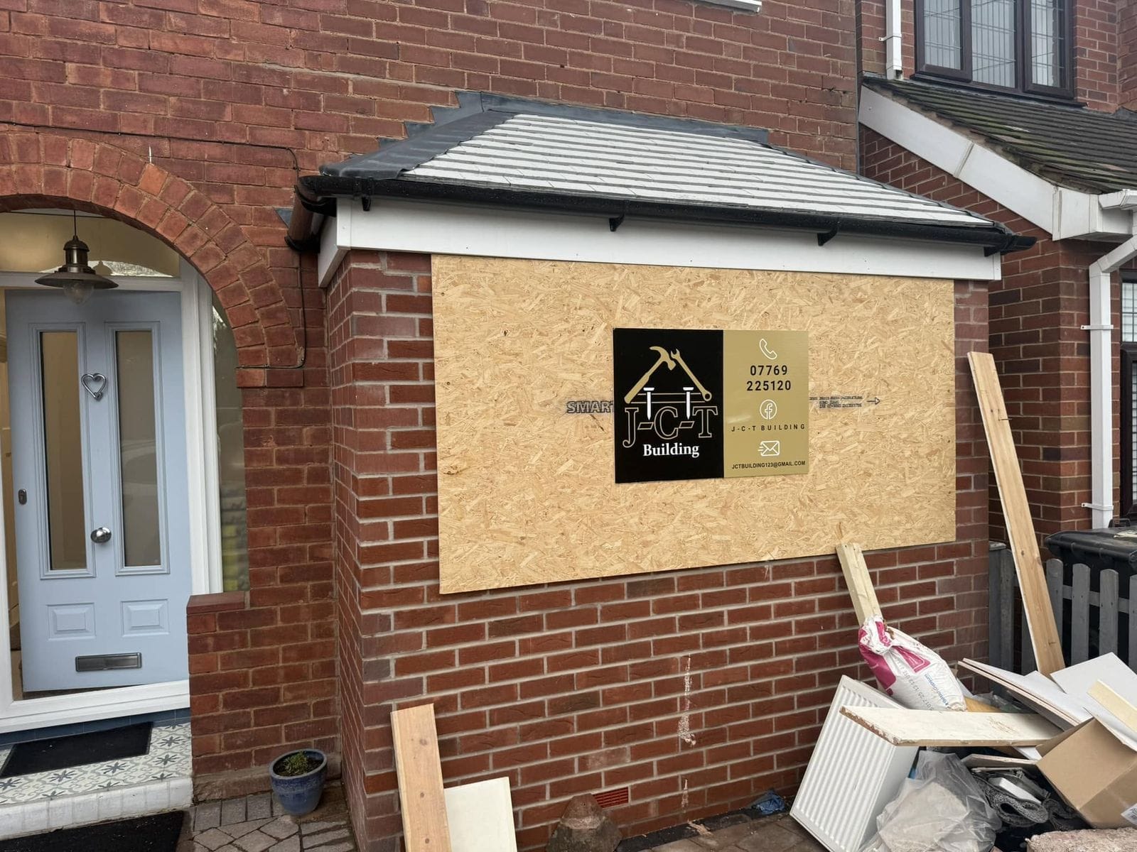 Front with the garage opening boarded and the JCT sign